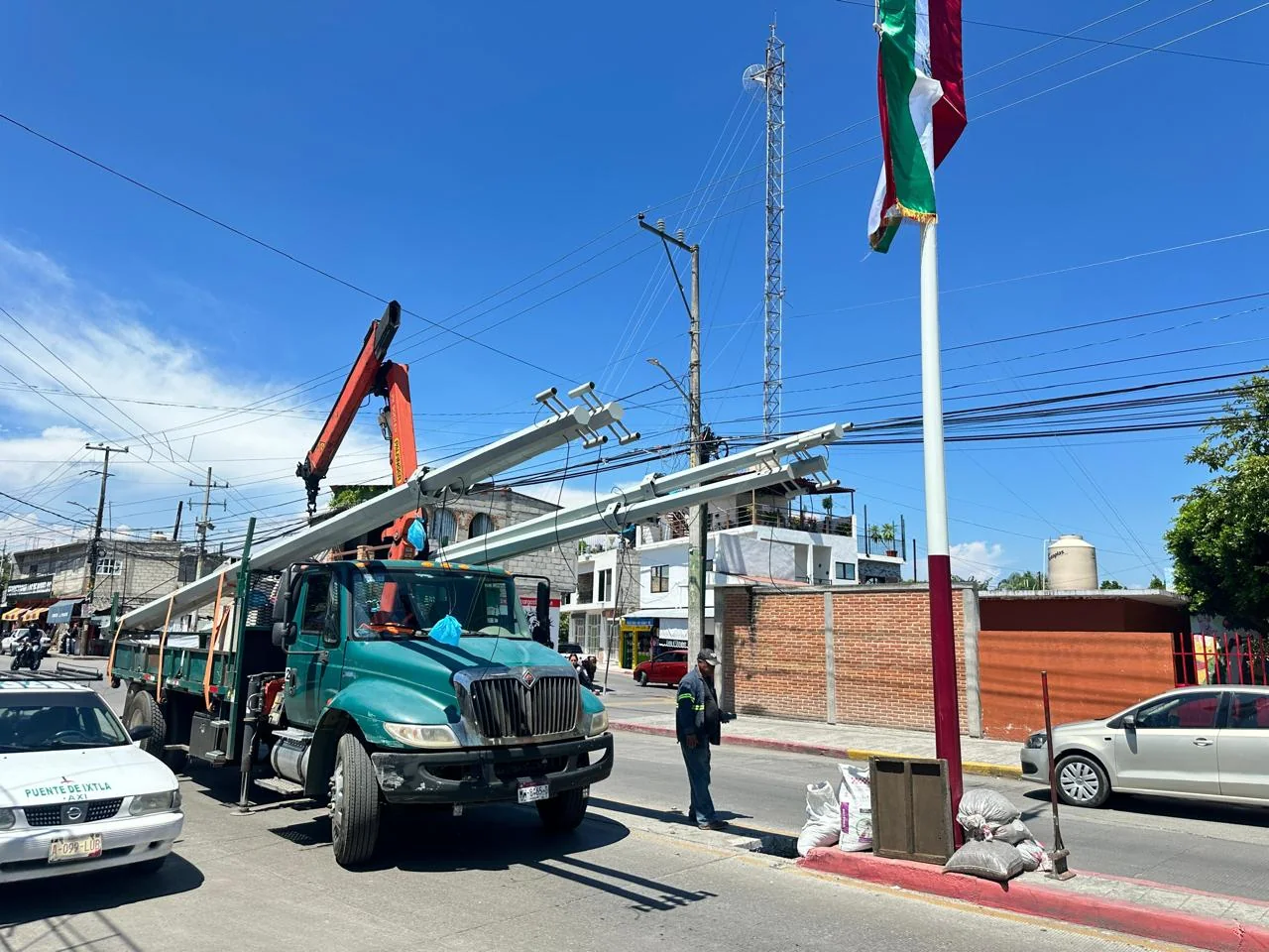 Grúa instalando postes de videovigilancia sobre avenida en Puente de Ixtla, Morelos